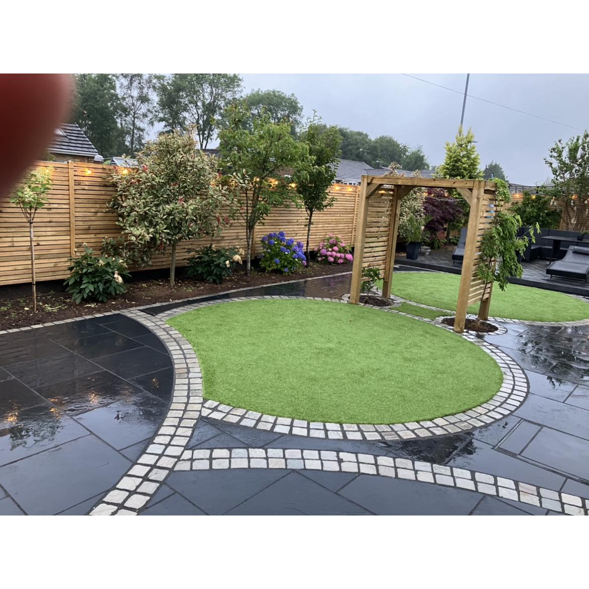 Full garden transformation with circular lawn, porcelain paving and pergola