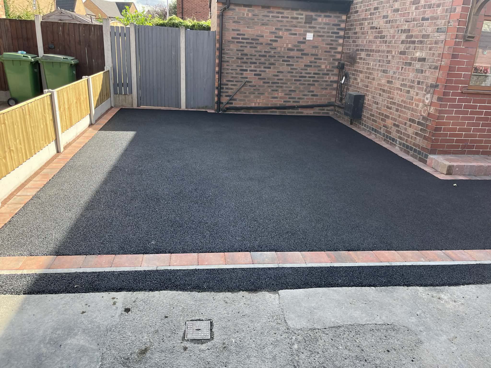 Tarmac driveway with red brick border