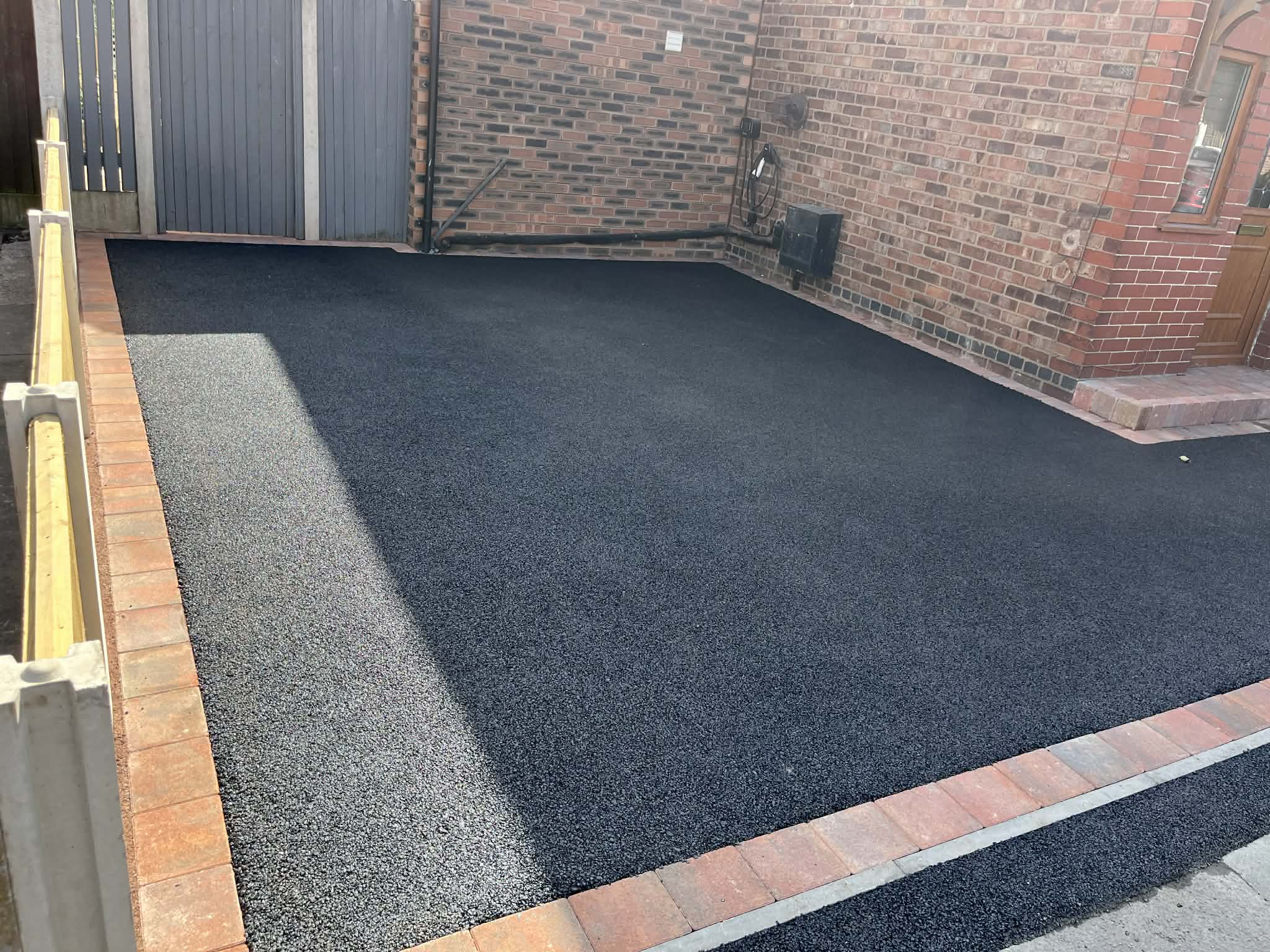 Tarmac driveway with red brick border
